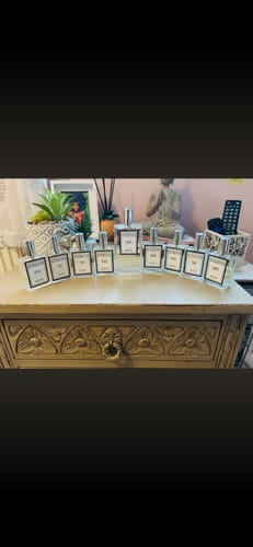 Customer's large collection of The Essence Vault perfumes arranged on a wooden dresser.
