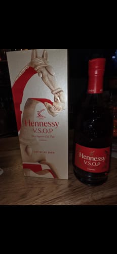 Customer's Hennessy V.S.O.P Year of the Horse bottle and decorative gift box displayed on a wooden surface.