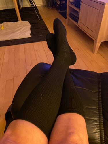 Anmelder slapper af med benene oppe iført de sorte, behagelige støttestrømper.