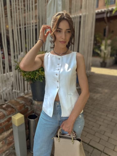 Customer's photo of a woman in a white vest and jeans, edited with the elegant Old Money Style Lightroom Presets.