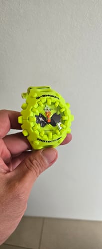 Un cliente sostiene en la mano su reloj Casio G-Shock amarillo.
