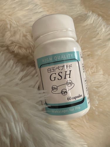 レビュアーの、ふわふわした白いラグの上に置かれたワカサプリ 白玉ペプチドのボトル。