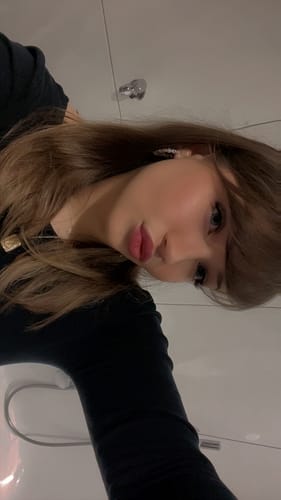 Eine Kundin blickt nach oben in die Kamera und zeigt die langen, geschwungenen Wimpern aus dem PRETTY WOMEN STARTER KIT.