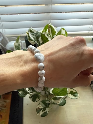 Customer wearing a white and grey howlite beaded bracelet from the VIP Crystal Club on their wrist.