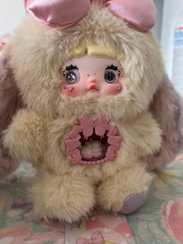 Customer's fuzzy Nommi Fantasy World Series plush doll with a large pink bow and an open detail on its chest.