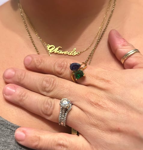 Reviewer wearing the gold Signature Name Necklace layered with another chain on their neck.