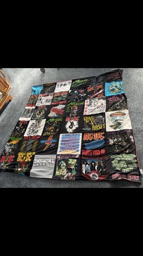 Reviewer's finished Premium T-Shirt Quilt made from 80s rock concert t-shirts, laid out flat on a carpet.