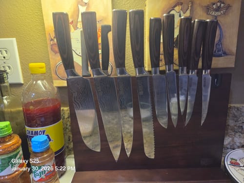 Customer's dark wood magnetic knife stand holding a full set of knives neatly on a kitchen counter.