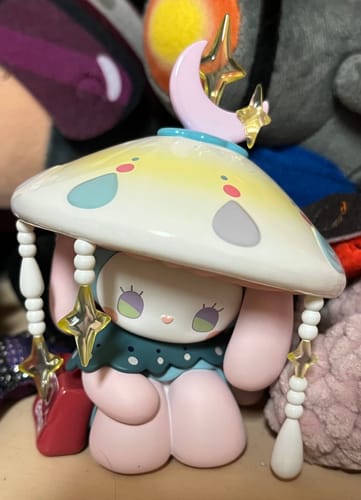 A customer's EMMA Secret Forest figure. The pink character wears a large, decorative mushroom hat with a moon and stars on top.