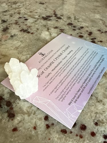 Customer's white clear quartz crystal from their monthly club, displayed on its info card on a countertop.