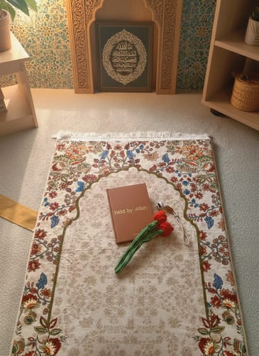 Customer's floral Barakah Padded Prayer Mat in a prayer corner with a book, crocheted tulips, and a tasbeeh on top.