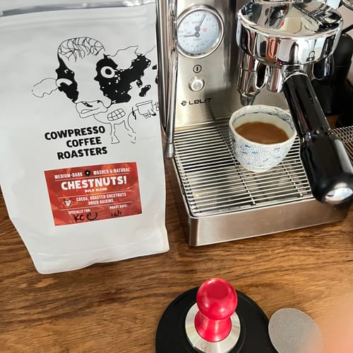 Reviewer's bag of ChestNuts! Bold Blend coffee sits next to a Lelit espresso machine with a freshly brewed shot.