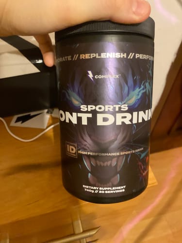Customer holding a black tub of Sports Iont Drink, showing the product's graphic label.