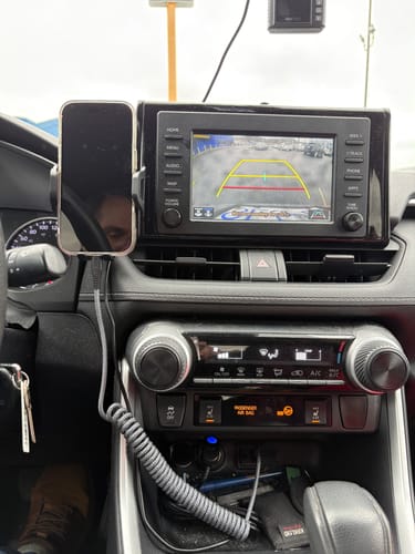 Customer's grey Piston Connect COIL cable charging a smartphone in a car mount.