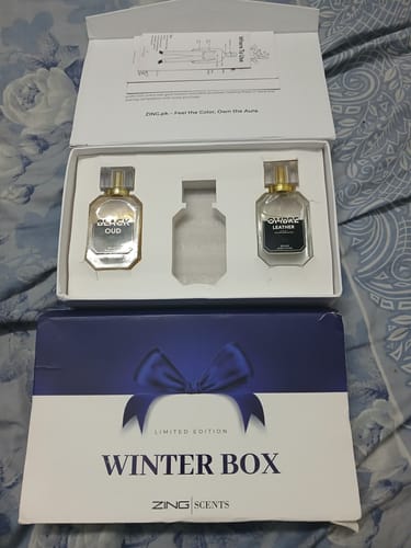 Reviewer's open Winter Box showing two of the three scents, Black Oud and Ombre Leather, with the outer packaging in front.
