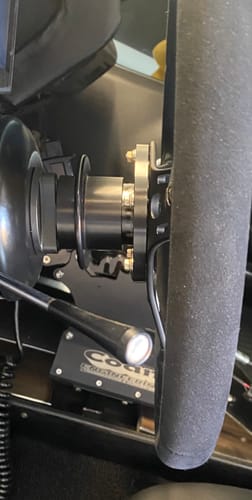 Customer's close-up side view of the black Motion Steering Quick Release Hub installed between the column and steering wheel.