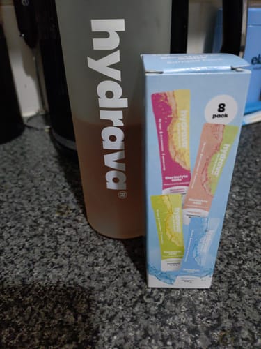 Customer's Sample Pack of Electrolyte Salts box next to a grey shaker bottle with the prepared drink.