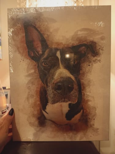 Customer holds their personalized pet portrait of a dog, printed on canvas in a watercolor style.