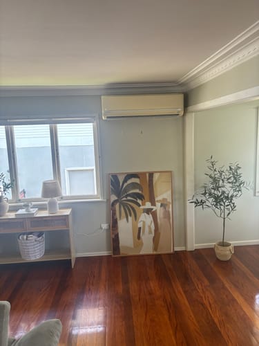 Reviewer's Block Palm II art print leaning on the floor against a light green wall in their home.