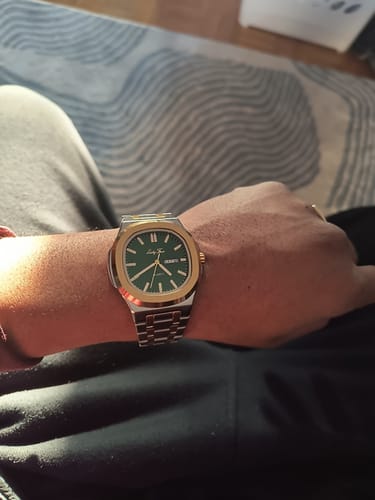 Customer wearing the Lucky Fours® Brone watch, showing its green face and two-tone metal band on their wrist.