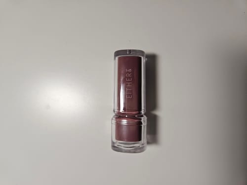 Customer's Eitherand Dewey Syrup Tint in a mauve-colored tube standing on a white surface.