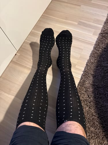 Anmelder, der har et par sorte, prikkede Støttestrømper på benene.