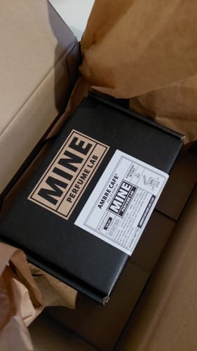 Scatola nera del profumo AMBRE CAFE' di un recensore all'interno di una confezione di spedizione.