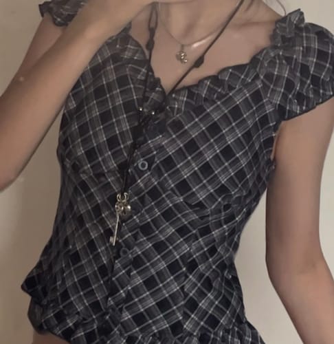 Customer wearing the Key 2 My Black Heart Long Necklace over a dark plaid top, showing the charms.