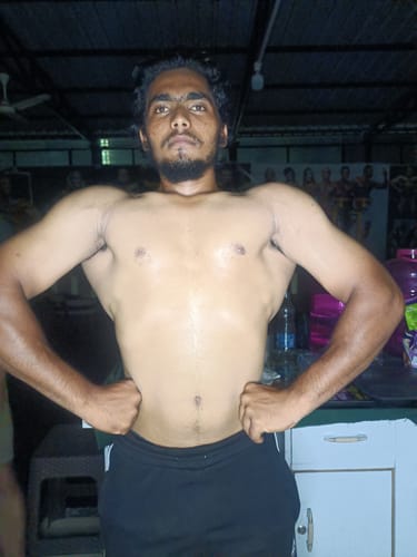 Reviewer flexing to show their muscular build after using Wellcore Creatine Monohydrate.