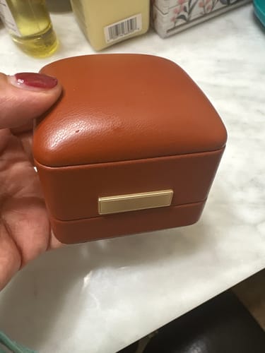 Reviewer holding the closed brown faux leather Sacred Ring Gift Box.