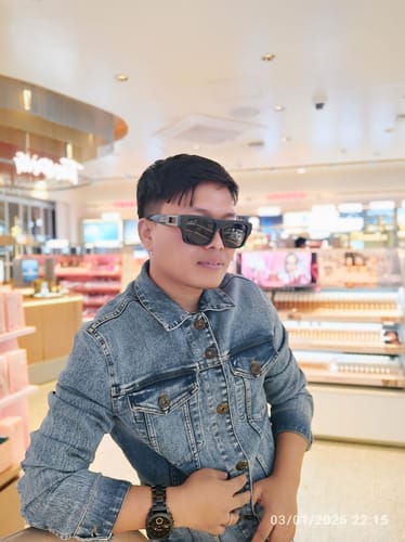 Reviewer wearing the black Square Sunglasses with grey lenses while indoors.