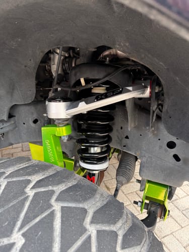 Customer's close-up of the installed aluminum forged upper control arm in the wheel well of a Ford F150.