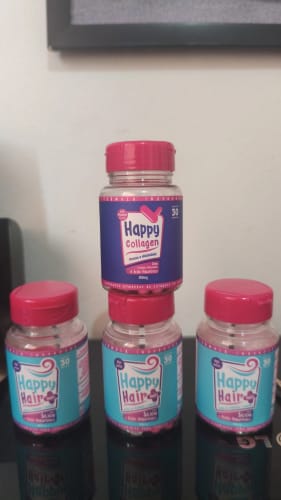 Cliente exibe três potes de Happy Hair e um de Happy Collagen empilhados sobre uma superfície.
