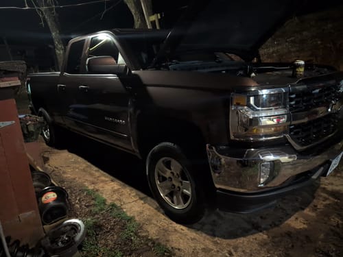 Customer's Chevy Silverado at night with the hood open, after installing the 2" front leveling lift kit.