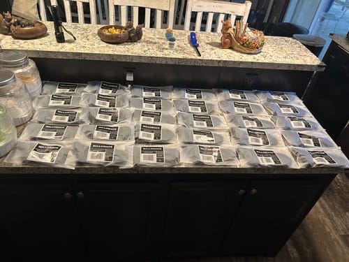 Customer's large order of Men's Alpaca Socks in their packaging, spread out across a kitchen island.