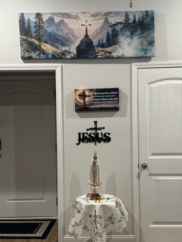 Customer's Cross On A Hill Faith Wall Art II hanging above a doorway as part of a religious display.
