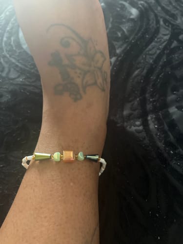 Close-up of a customer's ankle, adorned with the multi-colored beaded anklet.