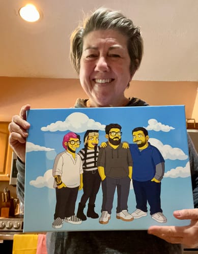 Customer smiling and holding a custom 'Turn Me Yellow' canvas portrait of four people.