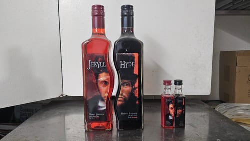 Customer's Jekyll & Hyde Two Liquid Liqueur Mini Shots shown with two full-size bottles of the red and dark liqueurs.