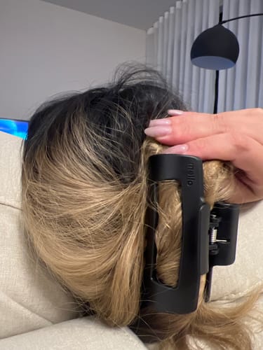 Customer's black cloud clip holding their two-toned hair up in a secure twist.