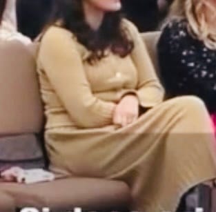 Vedere parțială a unei cliente așezate, care poartă setul Amill din tricot plisat camel.