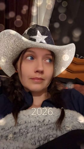 Customer wearing a sparkly hat shows off their vibrant blue eyes from the Amaretto Blue contact lenses.