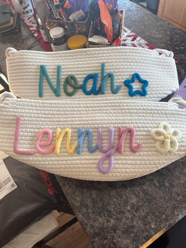 Customer's two personalized knitted baskets. One has 'Noah' with a blue star, and the other 'Lennyn' with a white flower.