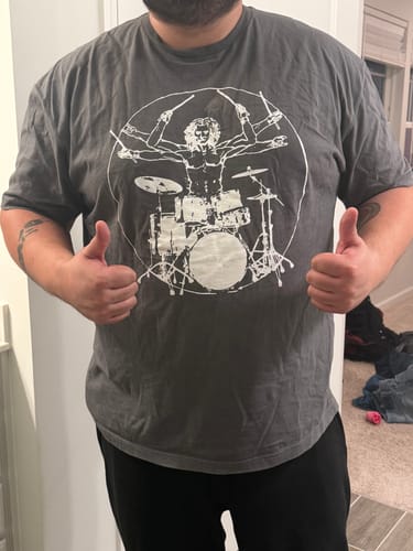 Reviewer wearing the dark grey Vitruvian Drummer T-Shirt while giving two thumbs up.