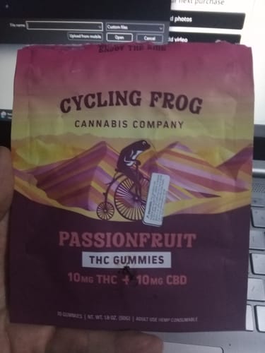 Customer holding the colorful pouch of Cycling Frog Passionfruit THC Gummies.