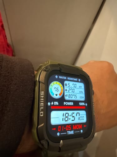 Reviewer's rugged Gard Pro Ultra smartwatch on their wrist. The digital display shows health metrics like steps and heart rate.