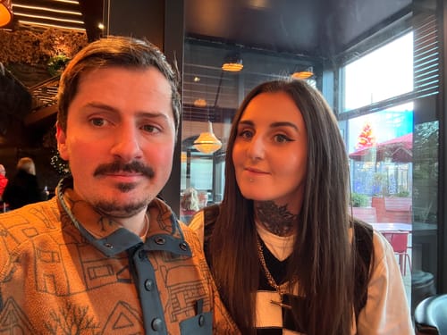 Reviewer wearing the chunky, gold XL T-Bar Necklace over a checkered top.