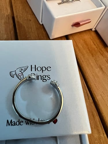 Customer's silver Paw Hug Ring resting on top of its white Hope Rings gift box.