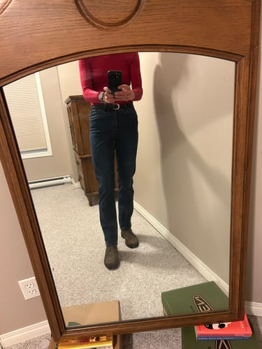 Cliente dans un égoportrait en miroir portant le jean New Gigi Jeans Droit pour en montrer la coupe ajustée.