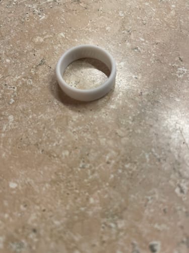 A customer's light-colored 4Love silicone ring resting on a marble-style countertop.